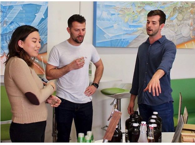 Tom Loebenstein running a kombucha and cold brew tasting for a group in an office.
